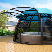 Modern outdoor cabana with curved glass walls on a wooden deck.